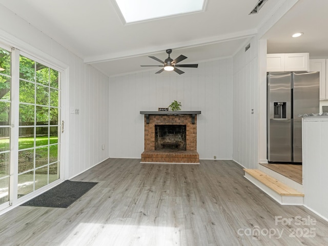 406 Wilcrest Dr, Matthews, NC 28105 - unfurnished living room with light wood-style flooring, ceiling fan, a brick fireplace, and beam ceiling
