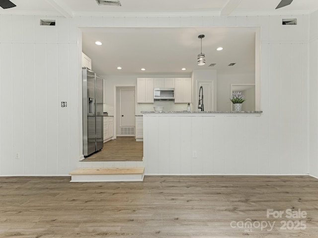 406 Wilcrest Dr, Matthews, NC 28105 - kitchen featuring appliances with stainless steel finishes, light wood finished floors, white cabinets, recessed lighting, and decorative light fixtures
