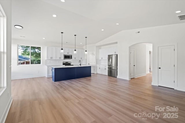 8632 Cedarbrook Dr, Charlotte, NC 28215 - kitchen featuring appliances with stainless steel finishes, a sink, arched walkways, white cabinetry, and light countertops