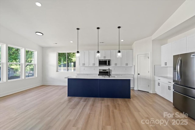 8632 Cedarbrook Dr, Charlotte, NC 28215 - kitchen featuring stainless steel appliances, light countertops, white cabinetry, light wood-type flooring, and decorative light fixtures