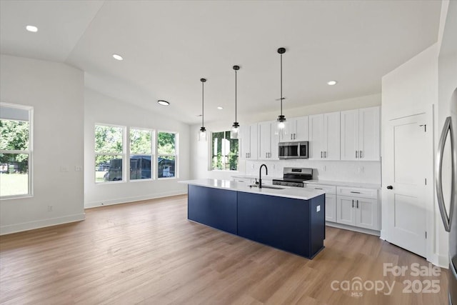 8632 Cedarbrook Dr, Charlotte, NC 28215 - kitchen featuring appliances with stainless steel finishes, a sink, white cabinetry, light wood-type flooring, and light countertops