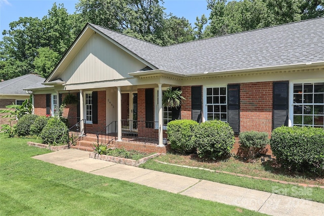2443 Knickerbocker Dr, Charlotte, NC 28212 - view of front of house featuring brick siding, a shingled roof, a front yard, and covered porch