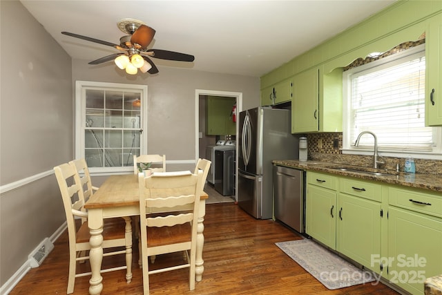 2443 Knickerbocker Dr, Charlotte, NC 28212 - kitchen with stainless steel appliances, washing machine and dryer, green cabinetry, dark wood-type flooring, and a ceiling fan