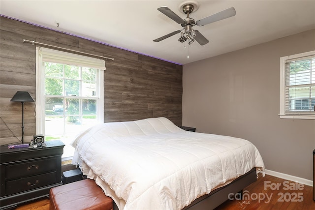 2443 Knickerbocker Dr, Charlotte, NC 28212 - bedroom featuring wood walls, wood finished floors, an accent wall, and a ceiling fan