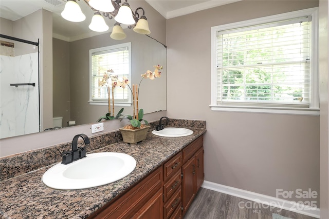 2443 Knickerbocker Dr, Charlotte, NC 28212 - bathroom with wood finished floors, double vanity, a shower stall, a chandelier, and crown molding