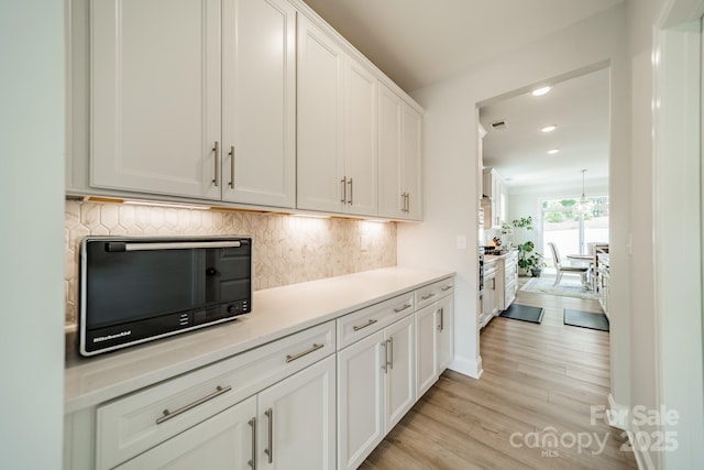 113 Summerhill Dr, Mooresville, NC 28115 - kitchen with light wood-style floors, decorative backsplash, white cabinetry, light countertops, and recessed lighting