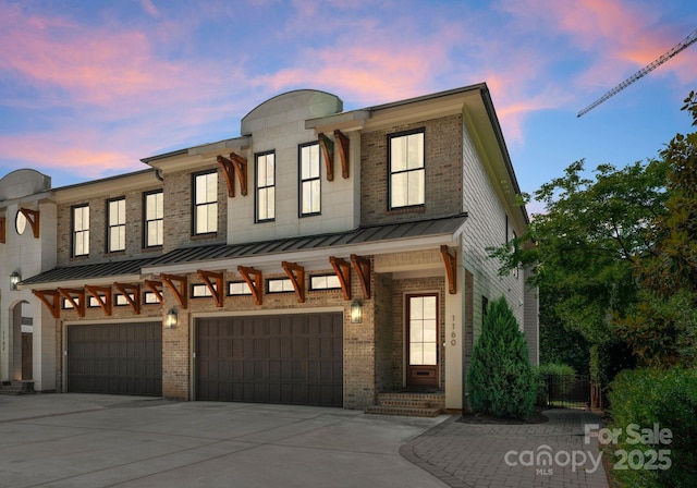 1160 S Kings Dr, Charlotte, NC 28207 - townhome / multi-family property with a standing seam roof, an attached garage, concrete driveway, brick siding, and metal roof