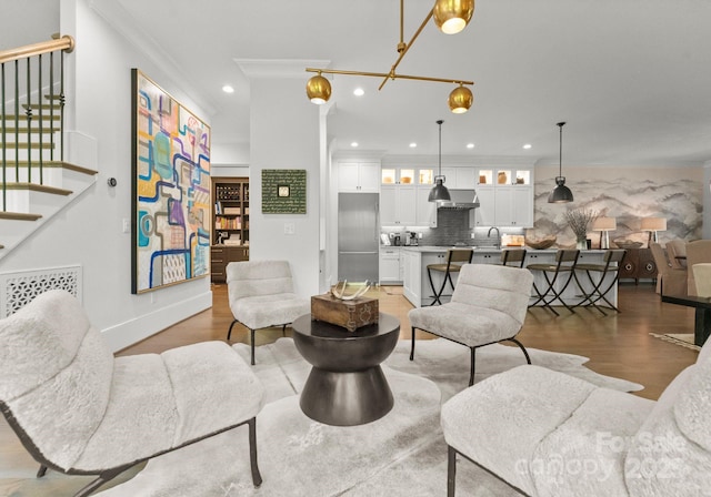 1160 S Kings Dr, Charlotte, NC 28207 - living room with stairway, light wood-type flooring, recessed lighting, crown molding, and baseboards