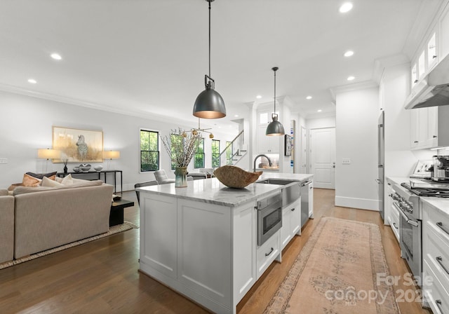 1160 S Kings Dr, Charlotte, NC 28207 - kitchen featuring high quality appliances, a sink, open floor plan, white cabinetry, and recessed lighting