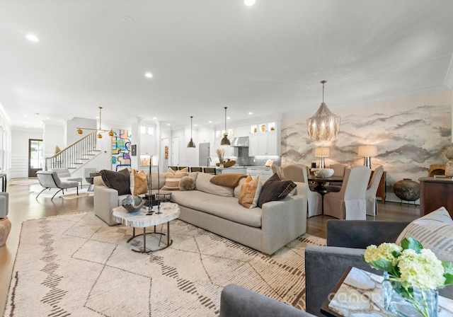 1160 S Kings Dr, Charlotte, NC 28207 - living room featuring wood finished floors, stairs, a chandelier, recessed lighting, and crown molding