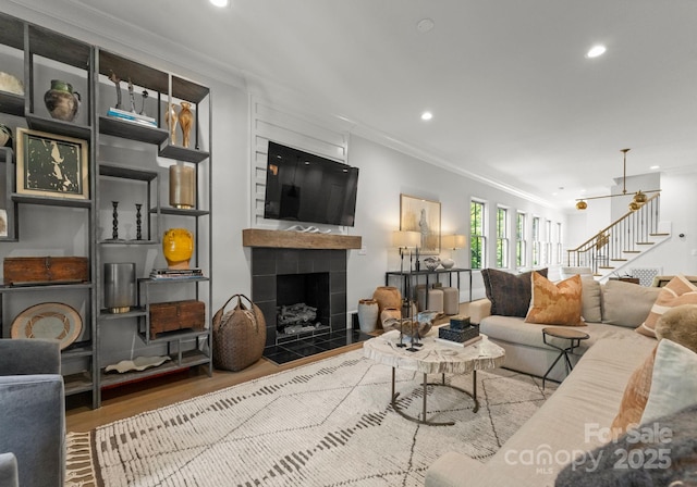 1160 S Kings Dr, Charlotte, NC 28207 - living area featuring crown molding, stairs, wood finished floors, recessed lighting, and a tiled fireplace