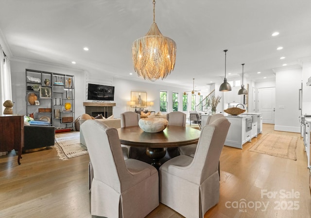 1160 S Kings Dr, Charlotte, NC 28207 - dining area featuring a chandelier, recessed lighting, light wood-style floors, and ornamental molding