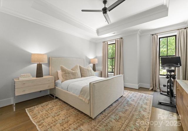1160 S Kings Dr, Charlotte, NC 28207 - bedroom featuring a tray ceiling, multiple windows, ornamental molding, wood finished floors, and baseboards