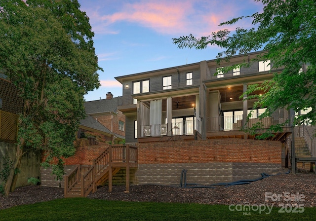 1160 S Kings Dr, Charlotte, NC 28207 - back of property at dusk with stairs and a ceiling fan