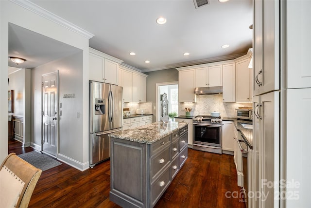 701 Larkridge Ct, Rock Hill, SC 29730 - kitchen with appliances with stainless steel finishes, under cabinet range hood, a center island, crown molding, and tasteful backsplash