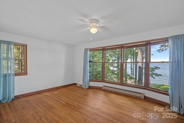 392 Stonemarker Rd, Mooresville, NC 28117 - spare room with a baseboard radiator, wood finished floors, ceiling fan, and baseboards