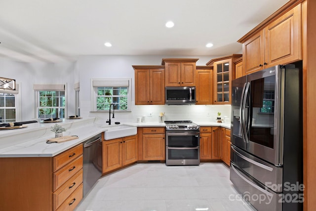 21 Hope Rd, Weaverville, NC 28787 - kitchen with stainless steel appliances, a sink, a peninsula, brown cabinets, and recessed lighting