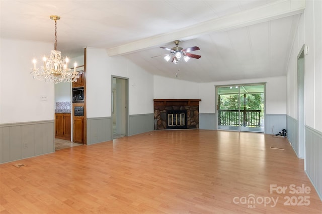 4648 Rifle Range Rd, Conover, NC 28613 - unfurnished living room featuring a wainscoted wall, wood finished floors, a chandelier, ceiling fan, and a stone fireplace