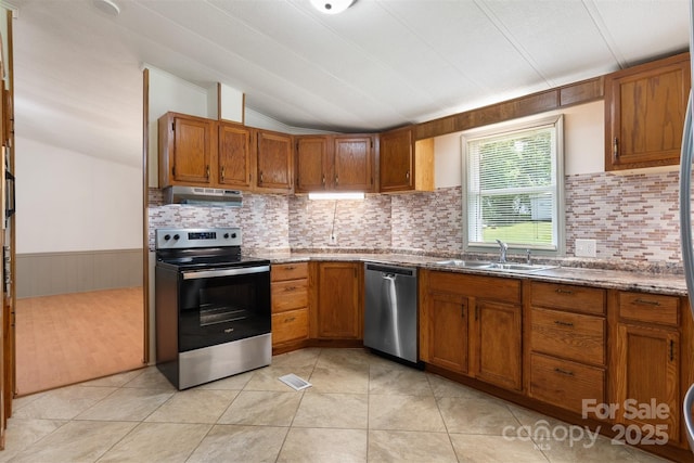 4648 Rifle Range Rd, Conover, NC 28613 - kitchen with stainless steel appliances, a sink, brown cabinetry, backsplash, and vaulted ceiling