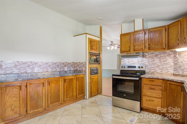 4648 Rifle Range Rd, Conover, NC 28613 - kitchen with stainless steel electric stove, under cabinet range hood, brown cabinets, black microwave, and backsplash