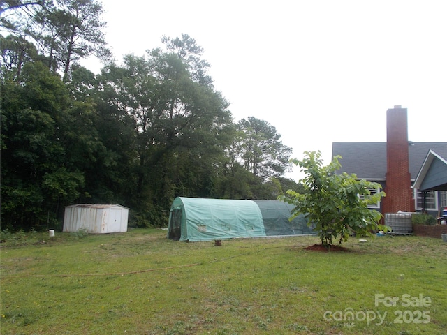 187 Cartledge Creek Rd, Rockingham, NC 28379 - view of green lawn with a greenhouse and central AC unit