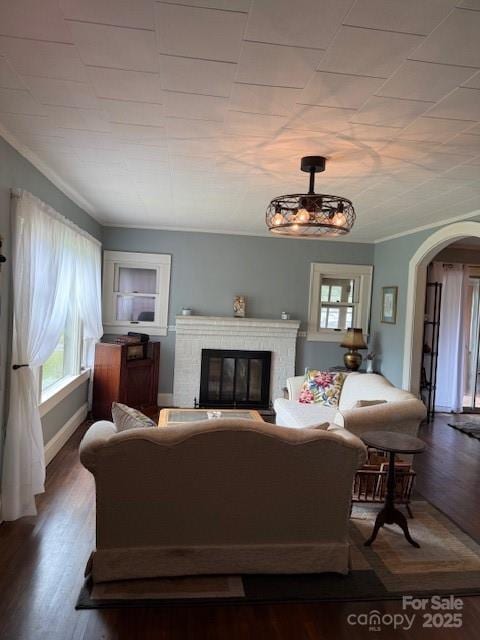 187 Cartledge Creek Rd, Rockingham, NC 28379 - living room featuring a brick fireplace, arched walkways, healthy amount of natural light, wood finished floors, and ornamental molding