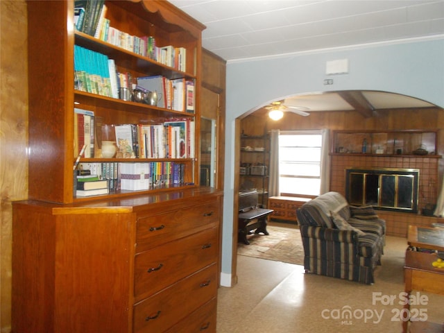 187 Cartledge Creek Rd, Rockingham, NC 28379 - living room with arched walkways, a glass covered fireplace, a ceiling fan, and crown molding