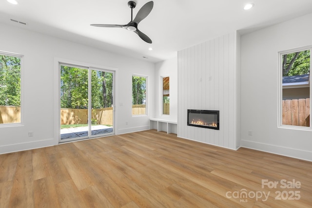 2004 St John St, Charlotte, NC 28216 - unfurnished living room with light wood finished floors, recessed lighting, a large fireplace, and ceiling fan