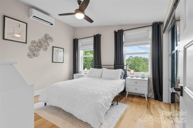 109 Thurland Ave, Asheville, NC 28803 - bedroom with a wall unit AC, light wood-style floors, and ceiling fan