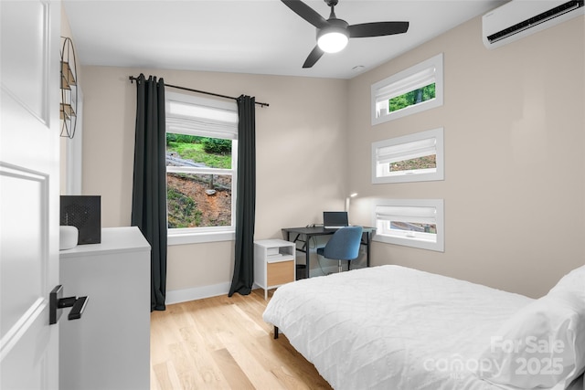109 Thurland Ave, Asheville, NC 28803 - bedroom featuring a wall mounted AC, light wood-style flooring, ceiling fan, and an office area