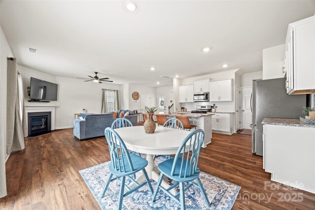 449 Misty Law Ln, Clover, SC 29710 - dining area featuring a ceiling fan, dark wood-type flooring, a glass covered fireplace, and recessed lighting