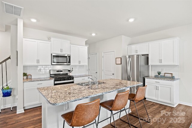 449 Misty Law Ln, Clover, SC 29710 - kitchen with appliances with stainless steel finishes, dark wood-style floors, backsplash, a kitchen bar, and recessed lighting