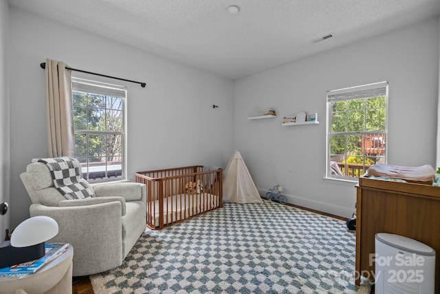 3801 Rosedown Dr, Matthews, NC 28105 - bedroom with multiple windows, a textured ceiling, a crib, and baseboards