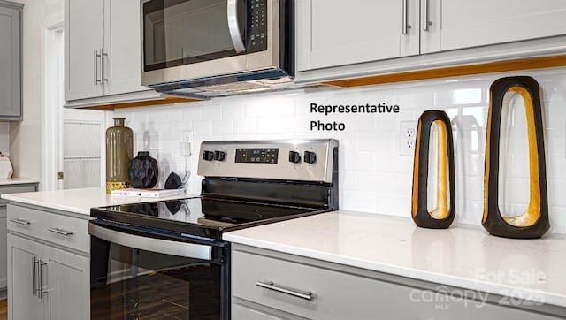 925 Two Brothers Ln, York, SC 29745 - kitchen with appliances with stainless steel finishes, gray cabinets, decorative backsplash, and light stone countertops