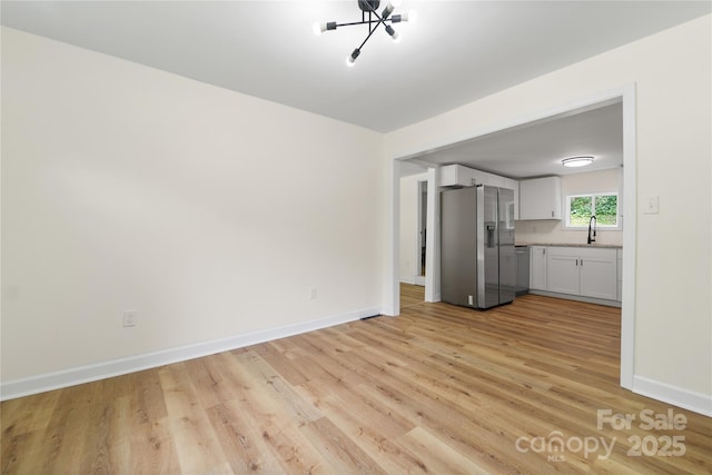 94 Camp Branch Rd, Black Mountain, NC 28711 - unfurnished living room with light wood-style flooring and a chandelier