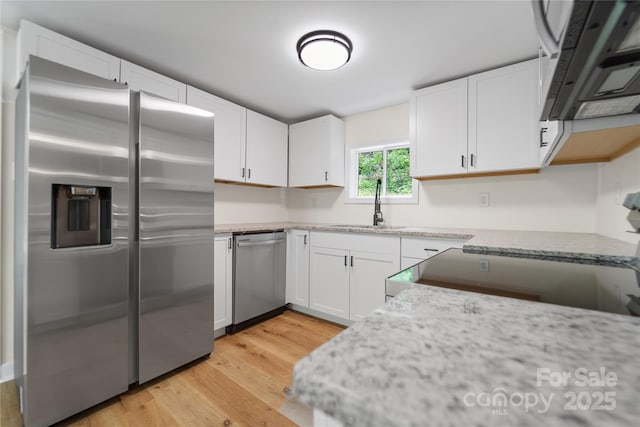 94 Camp Branch Rd, Black Mountain, NC 28711 - kitchen with stainless steel appliances, light wood-type flooring, white cabinetry, and light stone countertops