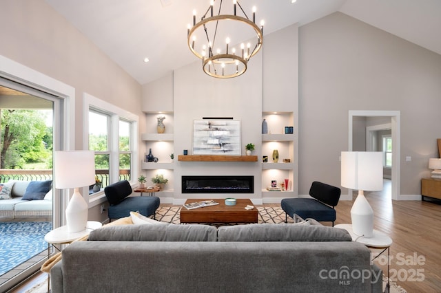 9 Robey Dr, Fletcher, NC 28732 - living room featuring high vaulted ceiling, built in features, wood finished floors, plenty of natural light, and a chandelier