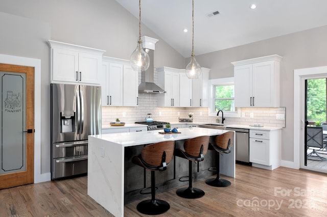 9 Robey Dr, Fletcher, NC 28732 - kitchen with appliances with stainless steel finishes, a kitchen island, decorative backsplash, white cabinets, and high vaulted ceiling
