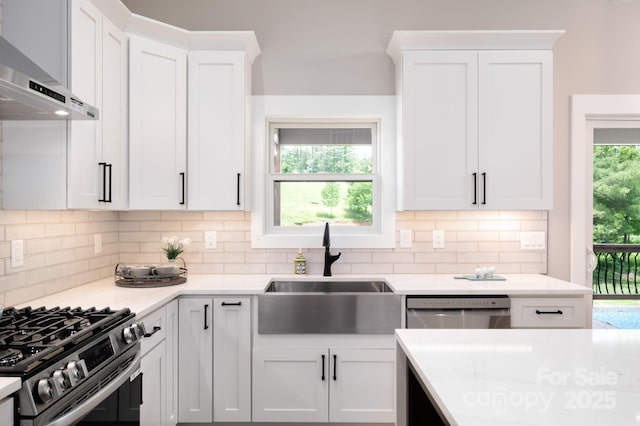 9 Robey Dr, Fletcher, NC 28732 - kitchen with wall chimney range hood, decorative backsplash, stainless steel appliances, light countertops, and white cabinets