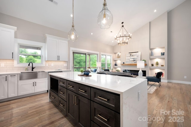 9 Robey Dr, Fletcher, NC 28732 - kitchen featuring white cabinetry, tasteful backsplash, light wood-style floors, vaulted ceiling, and a center island