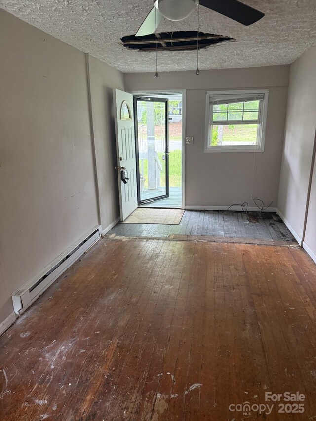 341 Talley St, Troutman, NC 28166 - unfurnished room with wood-type flooring, a baseboard heating unit, a textured ceiling, and baseboards