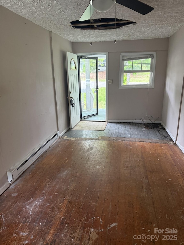 341 Talley St, Troutman, NC 28166 - unfurnished room with wood-type flooring, a baseboard heating unit, a textured ceiling, and baseboards