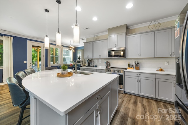 5088 Watersail Way, Clover, SC 29710 - kitchen with a sink, appliances with stainless steel finishes, gray cabinets, crown molding, and a breakfast bar