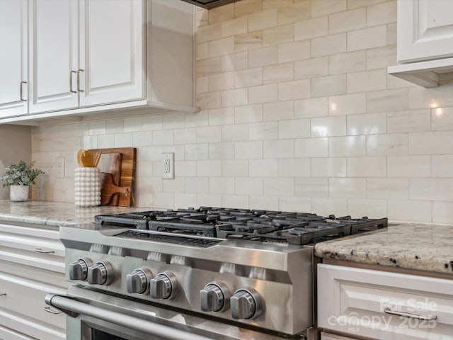 1008 Ladera Dr, Marvin, NC 28173 - kitchen view of gas range, tasteful backsplash, white cabinetry, and light stone countertops