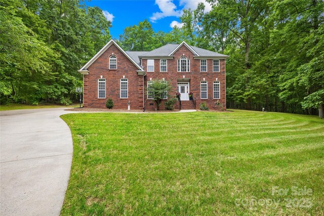 763 Evans Manor Dr, Weddington, NC 28104 - colonial-style house with brick siding, a front lawn, and concrete driveway