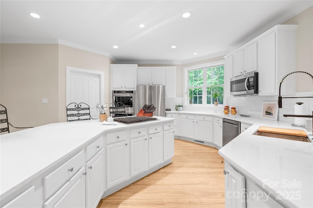 763 Evans Manor Dr, Weddington, NC 28104 - kitchen featuring stainless steel appliances, ornamental molding, a sink, tasteful backsplash, and light countertops