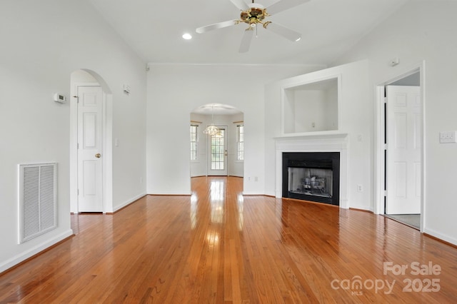 924 Secrest Hill Dr, Monroe, NC 28110 - unfurnished living room with arched walkways, a ceiling fan, light wood finished floors, and a fireplace