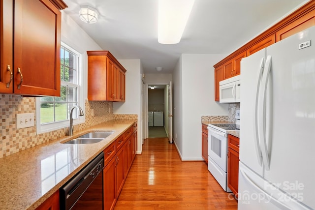 924 Secrest Hill Dr, Monroe, NC 28110 - kitchen with white appliances, a sink, washing machine and clothes dryer, light wood finished floors, and decorative backsplash
