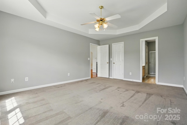 924 Secrest Hill Dr, Monroe, NC 28110 - unfurnished bedroom with a tray ceiling, baseboards, carpet flooring, ensuite bathroom, and a ceiling fan