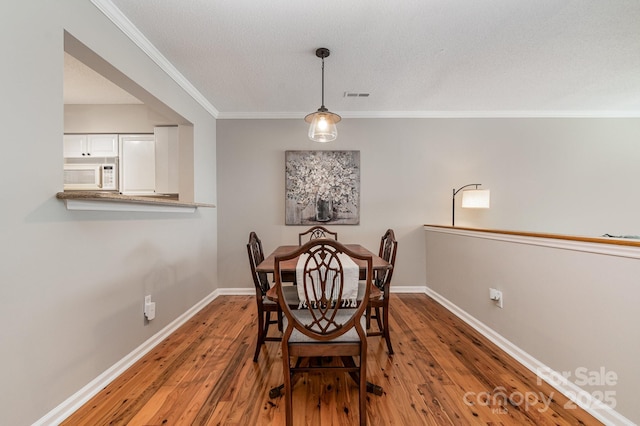4124 Melrose Club Dr, Matthews, NC 28105 - dining space with ornamental molding, hardwood / wood-style flooring, baseboards, and a textured ceiling